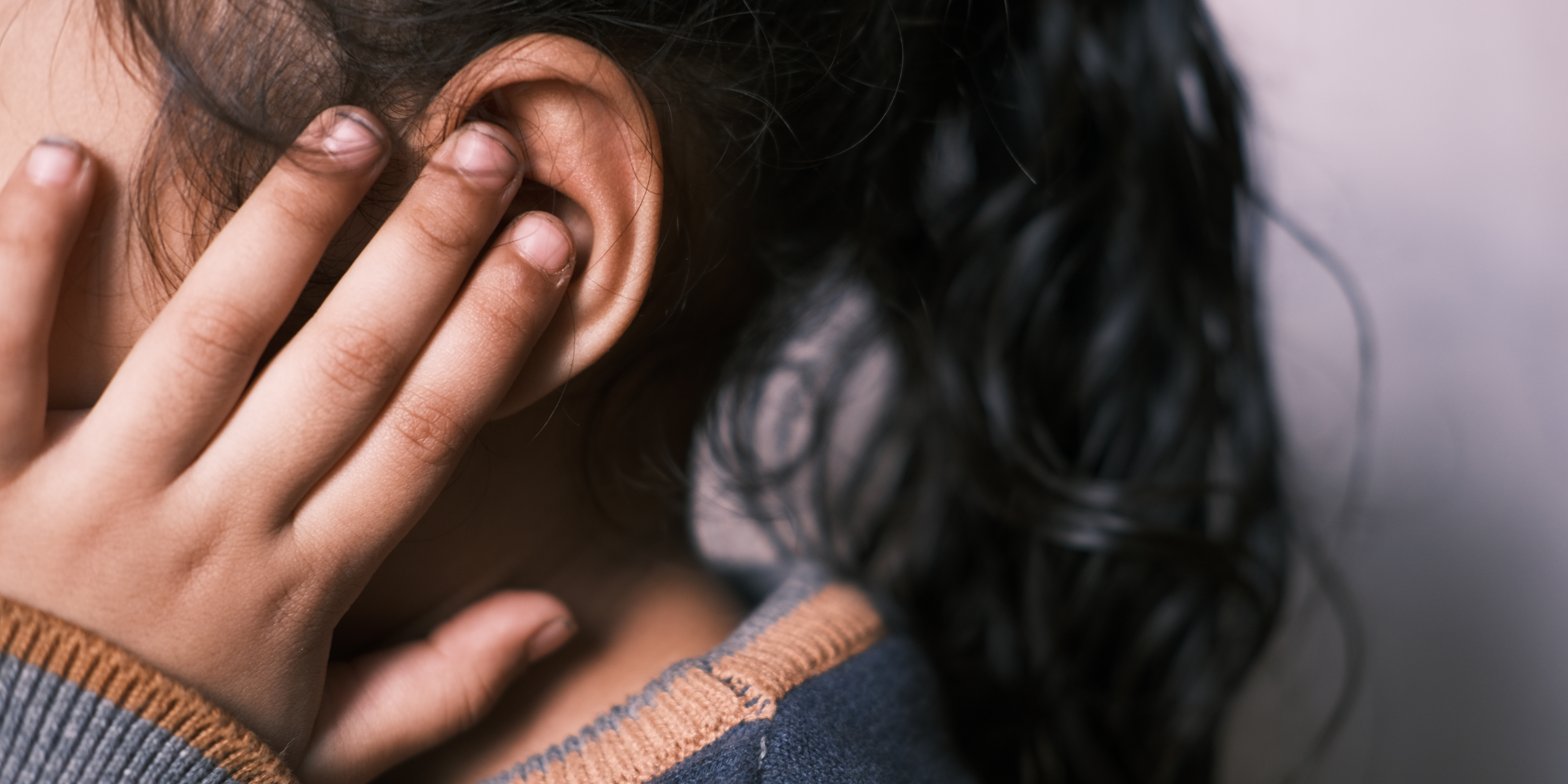 A picture of a child touching their ear