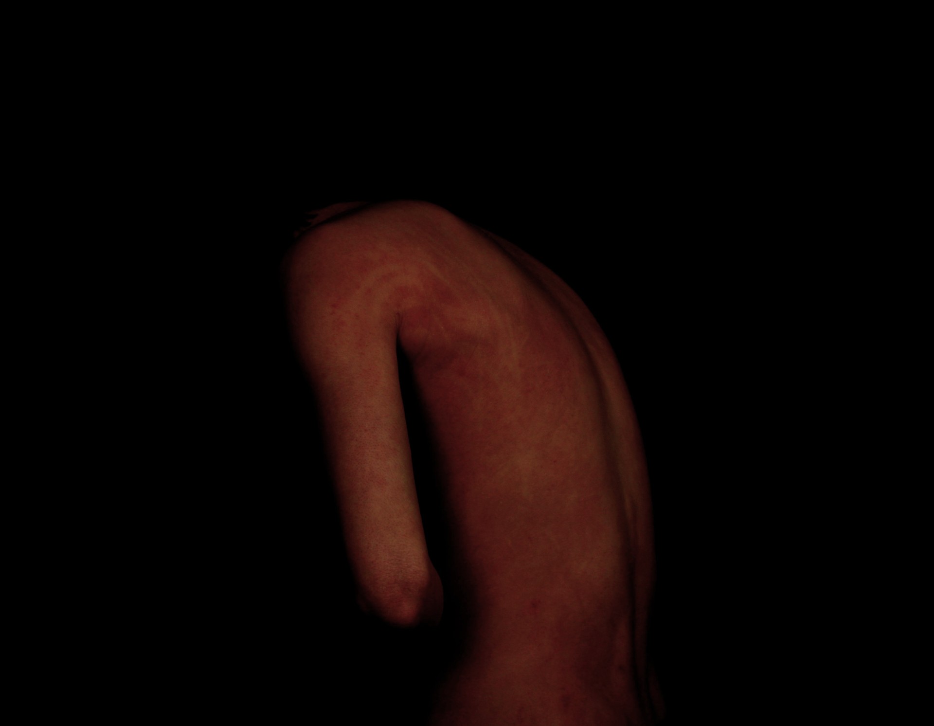A picture of Craig hunched over, only his red back visible.