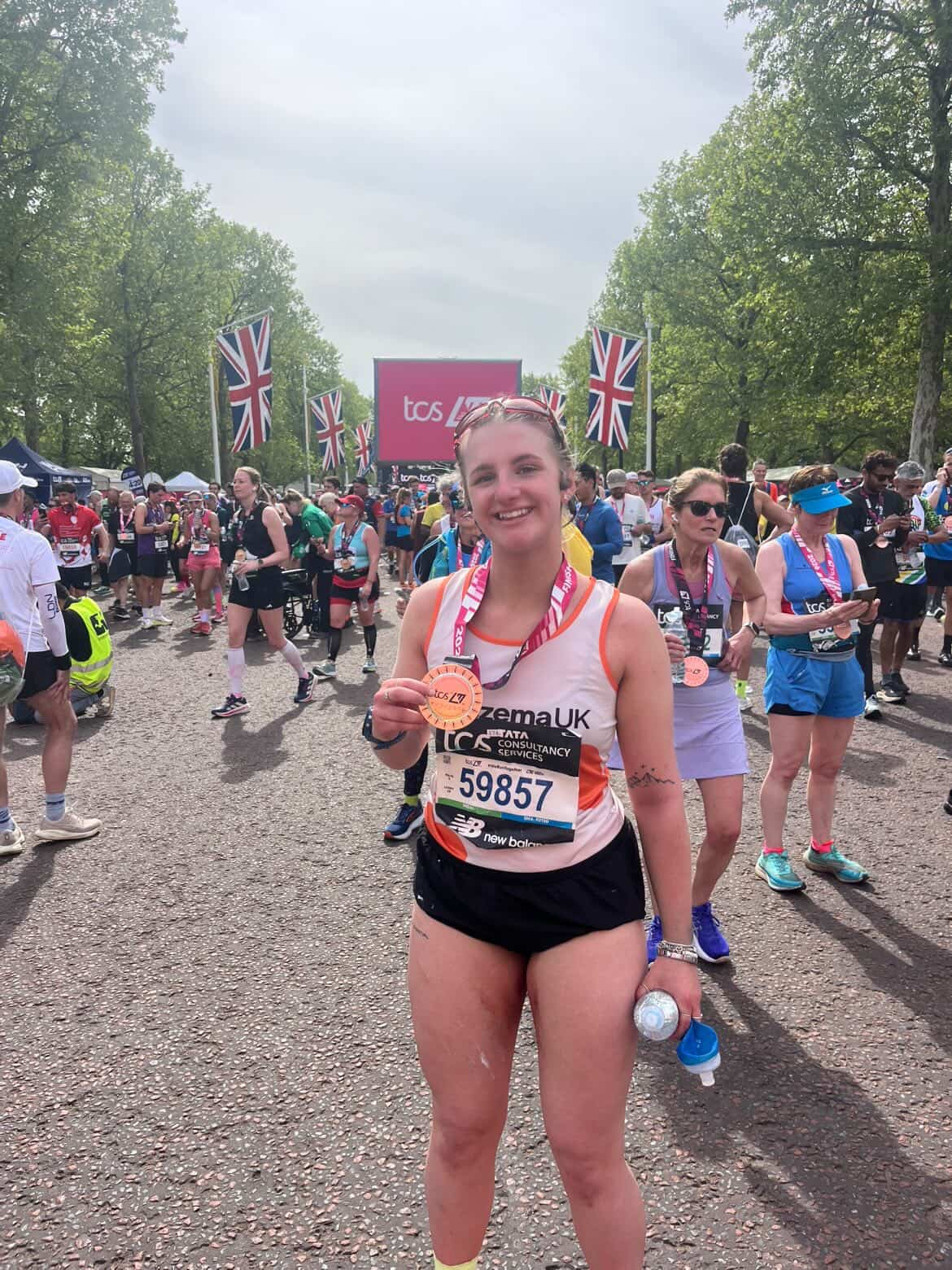 Isla, smiling and holding her london marathon winners medal