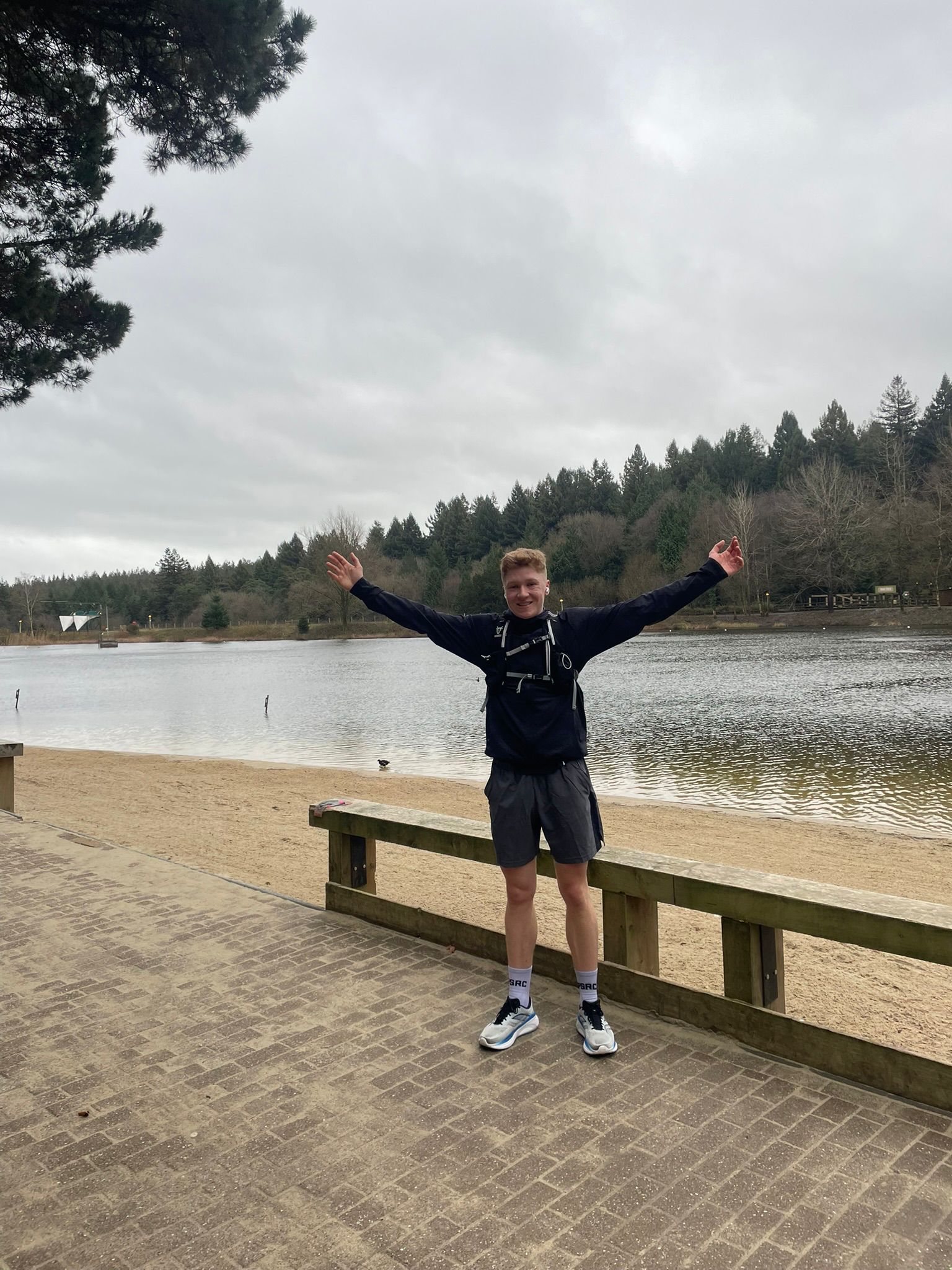 Toby celebrating after a run infront of a beach.