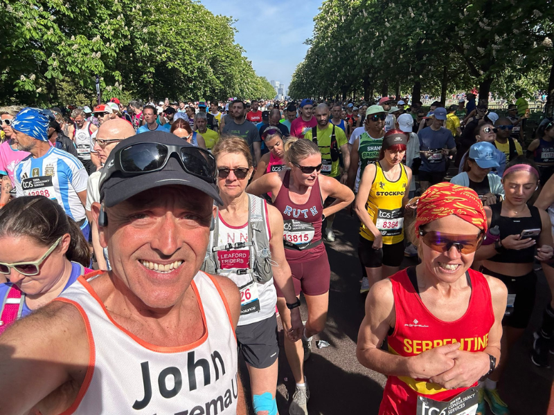 A runner in an eczema uk mid race smiling at the camera.