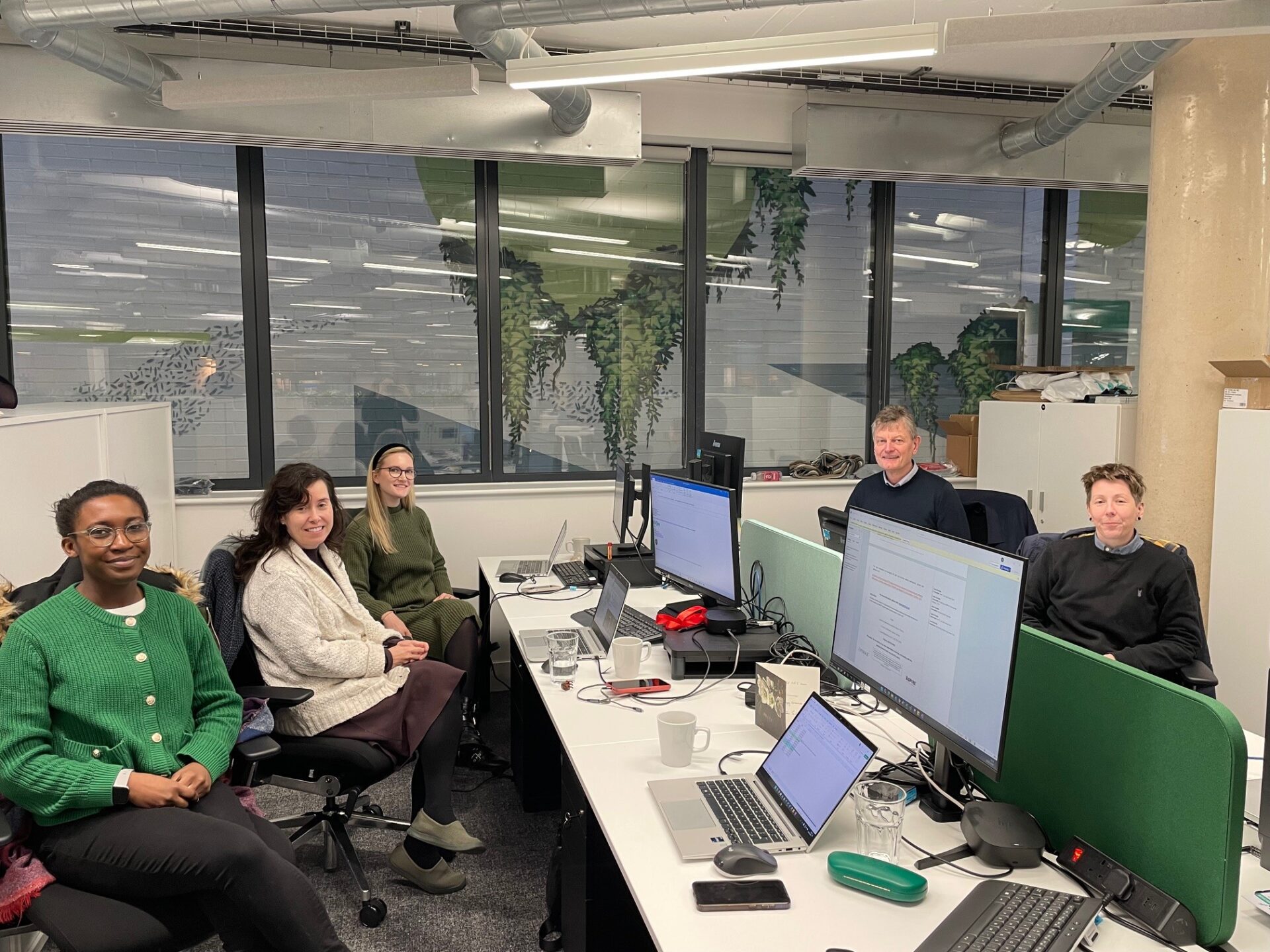 a picture of five people sitting at desks